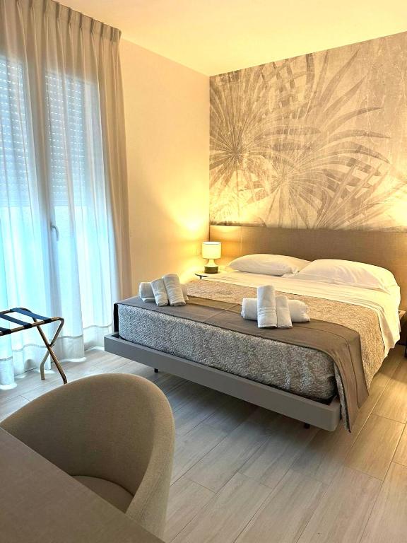a bedroom with a large bed and a chair at The Rooms Catanzaro Lido in Catanzaro Lido
