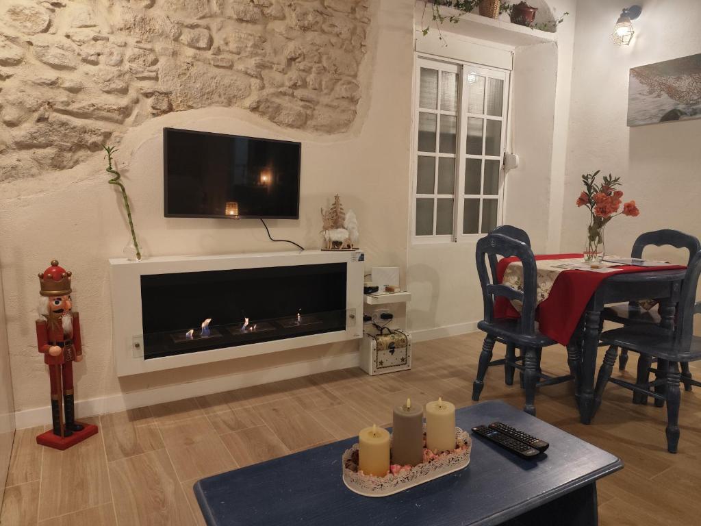 ein Wohnzimmer mit Kamin und Fernseher in der Unterkunft Maktub Medina in Medina-Sidonia