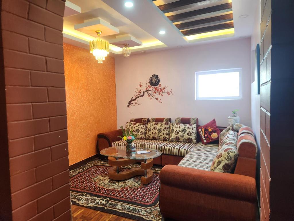 a living room with a couch and a table at Below The Hills suite WHome Theatre in Kathmandu