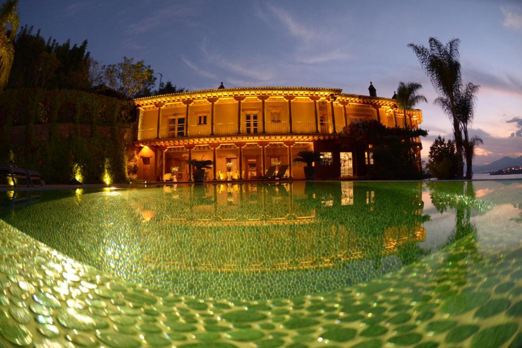 a building with a pool of water in front of it at Hacienda Ucazanaztacua in Pátzcuaro