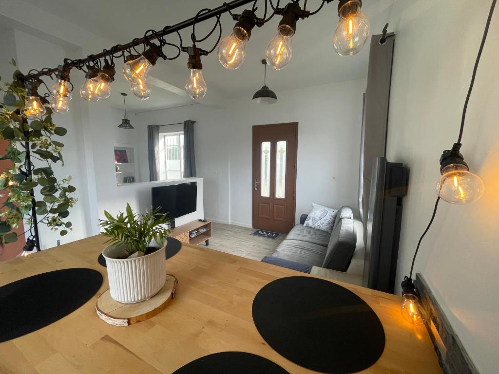 a living room with a wooden table and lights at Studio Cosy avec déco artisanale unique in Voeuil-et-Giget