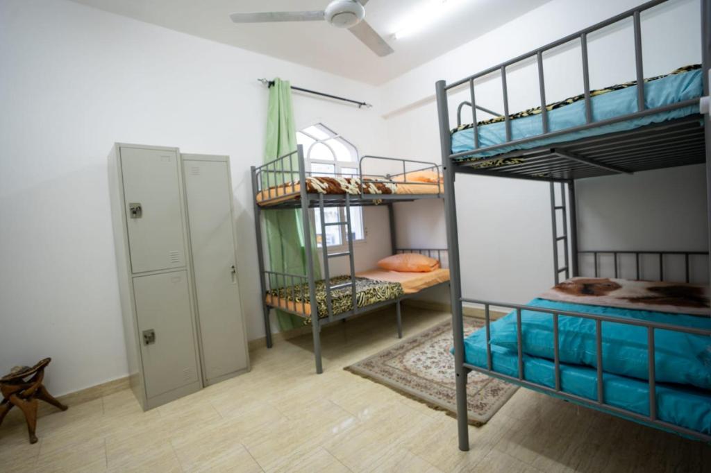 une chambre avec deux lits superposés et un placard dans l'établissement Mozna Hostel, à Mascate