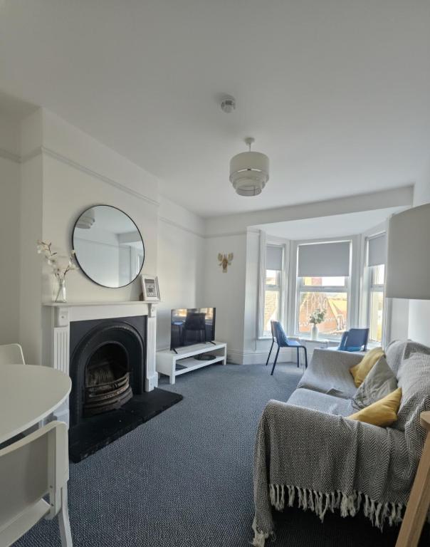 a living room with a couch and a mirror at The Exmouth Hideaway in Exmouth