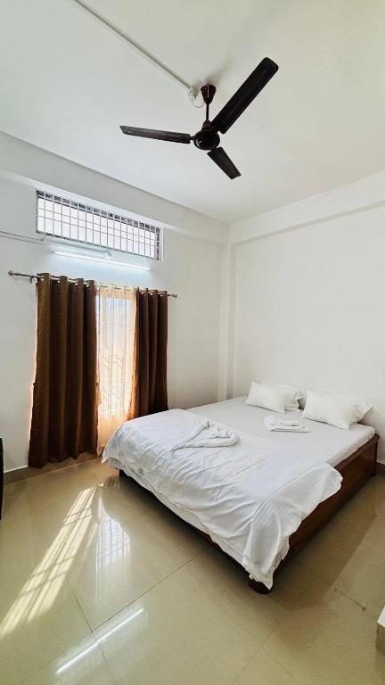 a bedroom with a bed with a ceiling fan at Toncheng Homestay in Kāziranga