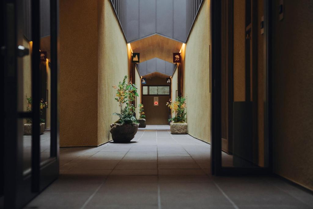 a hallway of a building with two potted plants at casana KYOTO in Kyoto
