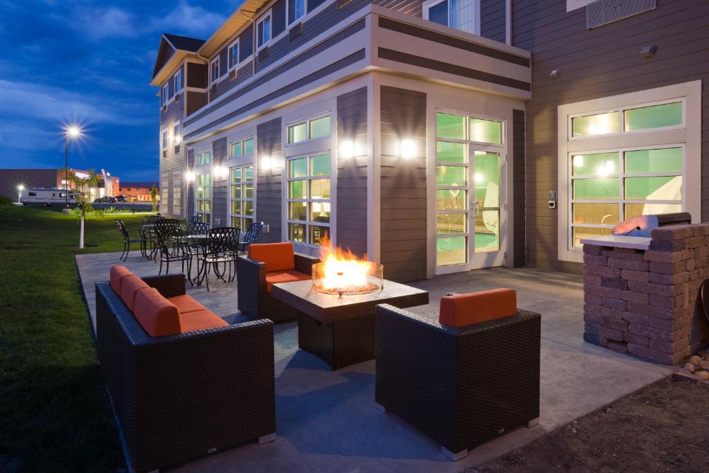 a patio with a fire pit with chairs and tables at GrandStay Hotel & Suites Valley City in Valley City