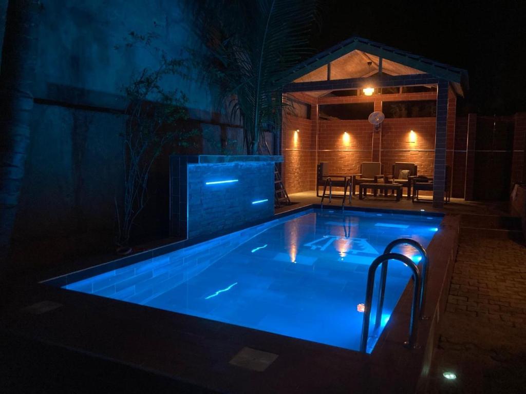 een zwembad 's nachts met blauwe lichten bij Tekrour- La case des hotes -Chambre lumineuse proche plage in Mbour