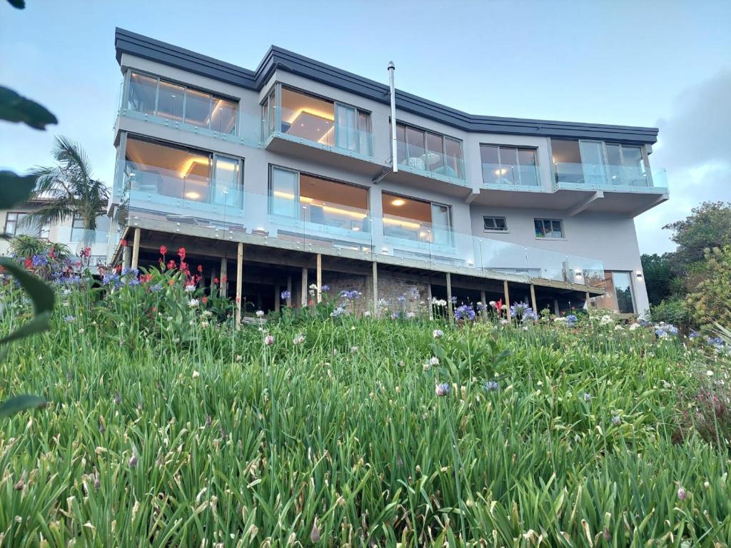 un edificio con finestre e un campo di fiori di Salt & Soul a Herolds Bay