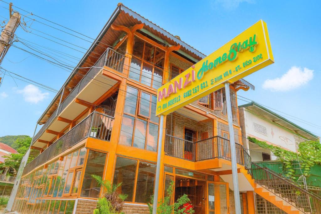 un edificio con un cartel delante en MÀN ZÌ Homestay, en Mèo Vạc