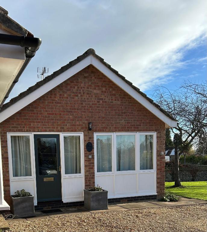 a red brick house with a white door at The Nest in Bourne