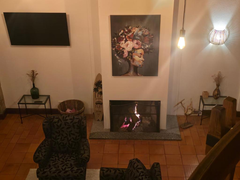 a living room with a fireplace and a tv at Aqua Vista Monchique Hôtel in Monchique