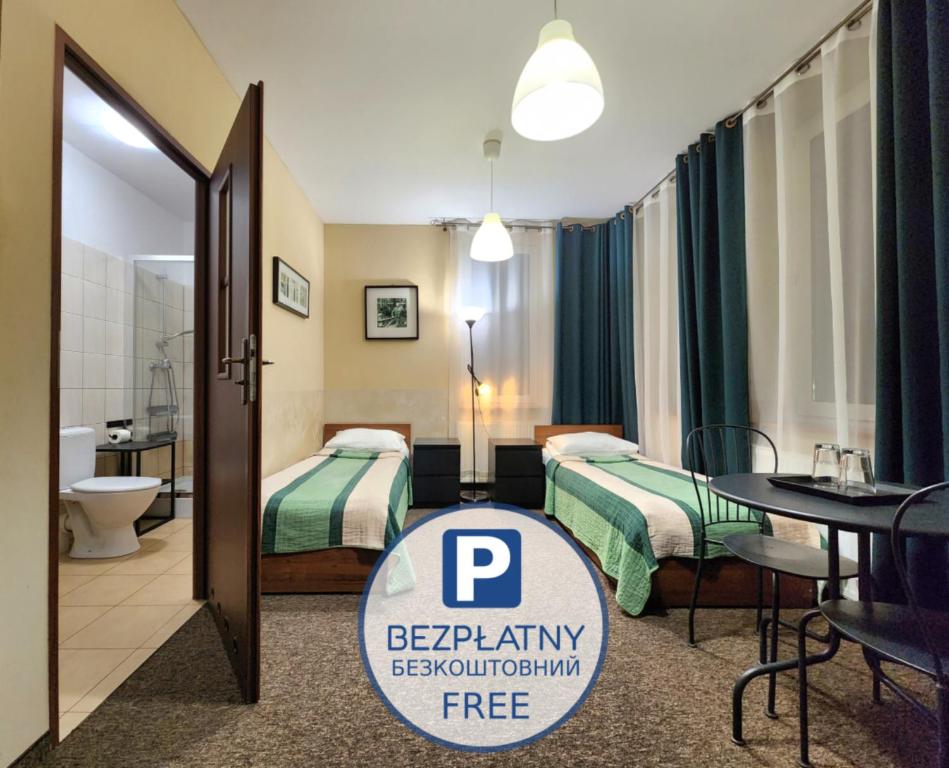 a hotel room with two beds and a bathroom at Hostel Zamość - pokoje gościnne - bezpłatny parking in Zamość