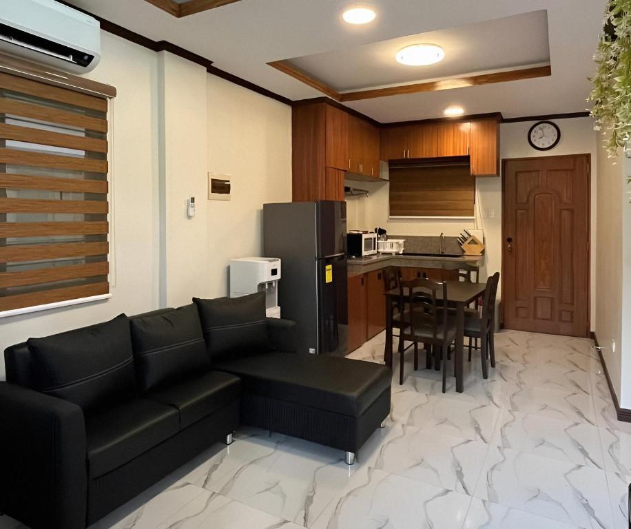 uma sala de estar com um sofá e uma cozinha em Ranch-o-tel Guesthouse em Sampong