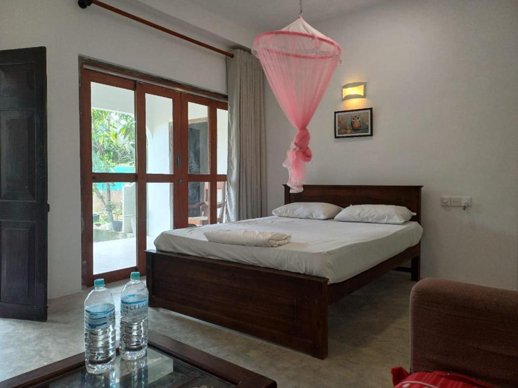 a bedroom with a bed and two water bottles on a glass table at villa Calm Haven in Unawatuna