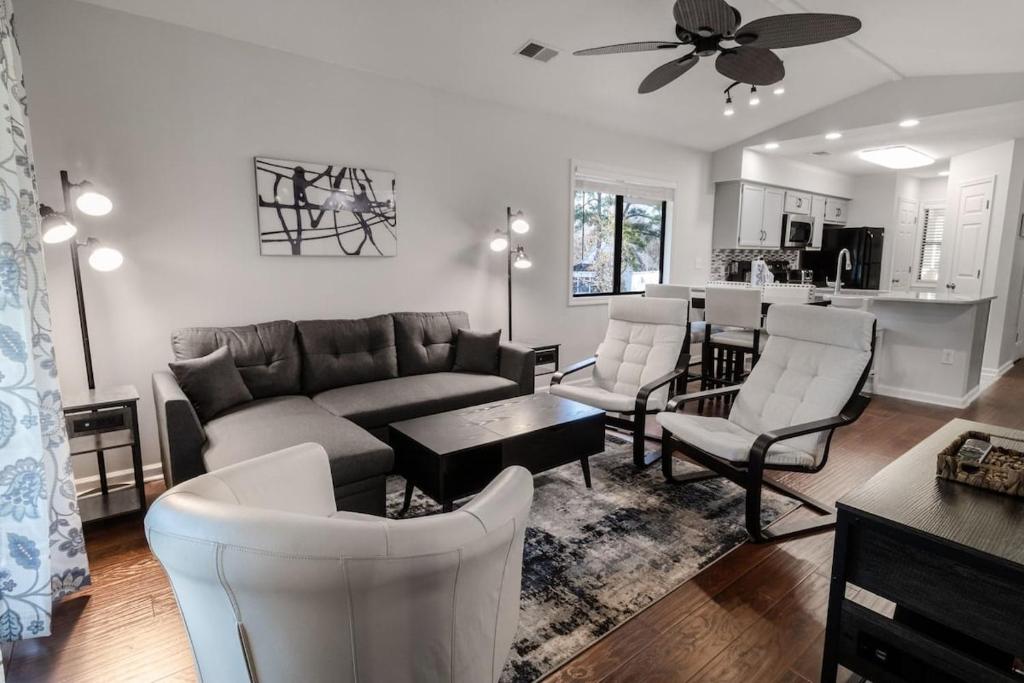 Una sala de estar con un sofá y sillas y una cocina. en Cypress Bay EE15, en Little River