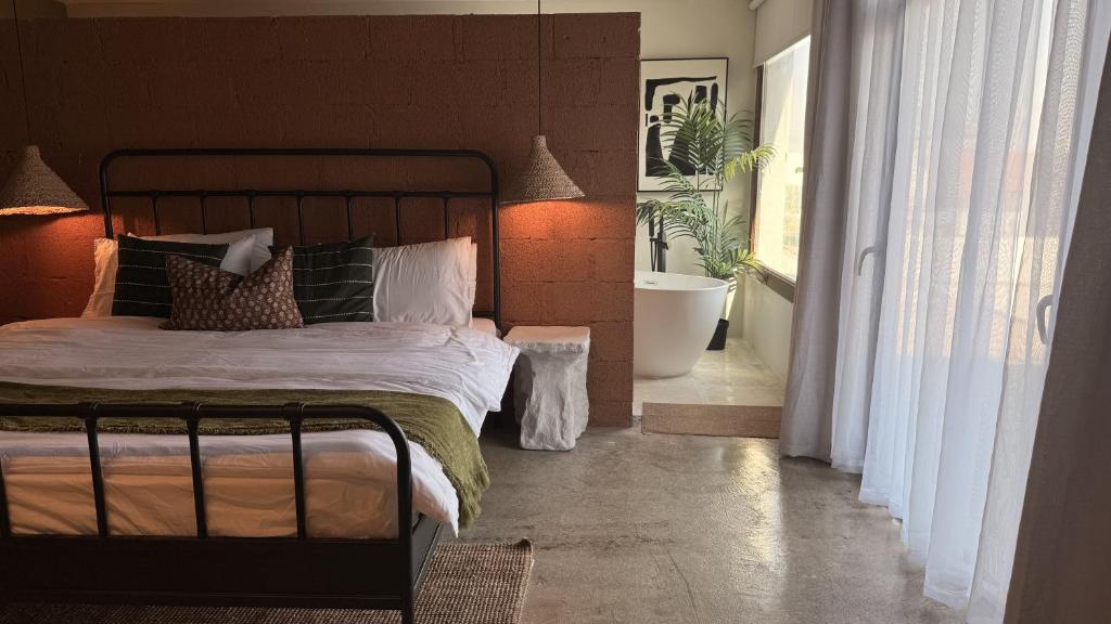 1 dormitorio con cama y baño con bañera en concrete villa, en Badīyah