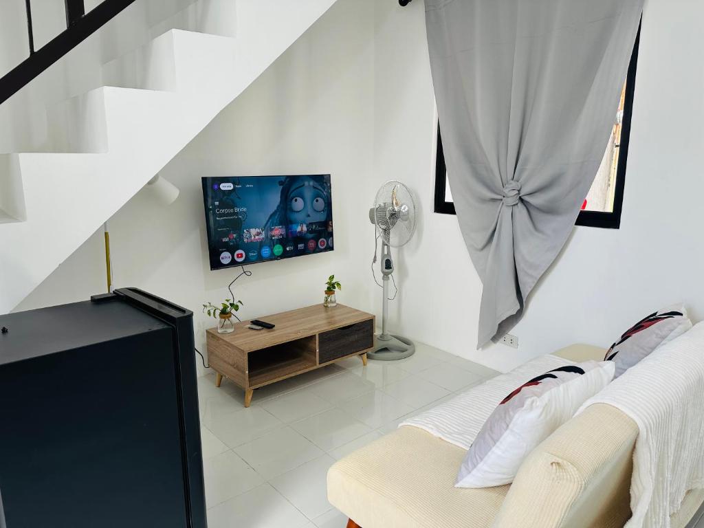 un soggiorno con TV e divano di 2BR Near Clark - Fast Wifi - Self Check-in a Mabalacat