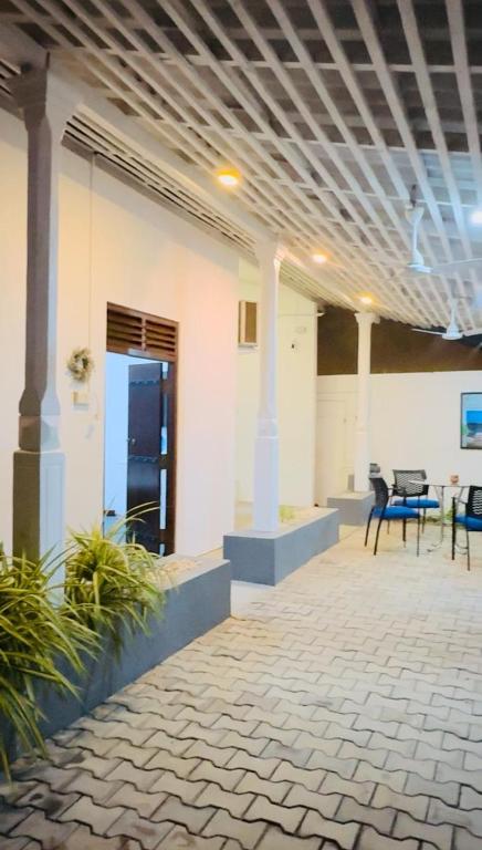 a room with a patio with tables and chairs at Traveler's Cottage in Unawatuna