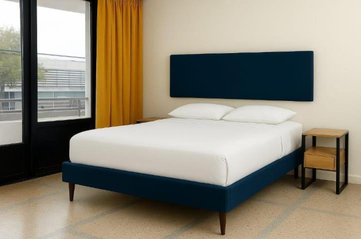 a bedroom with a blue and white bed and a window at colibrí Hostel in Armenia