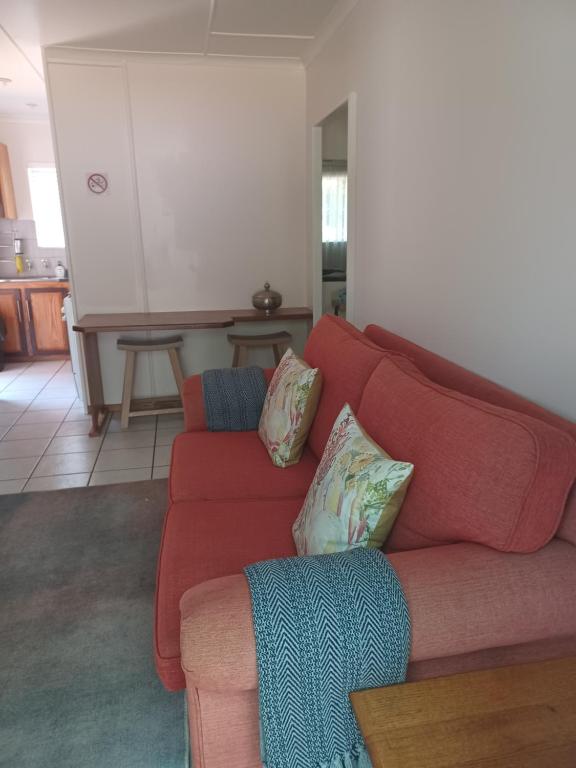a living room with a red couch and a table at The Roaches in White River