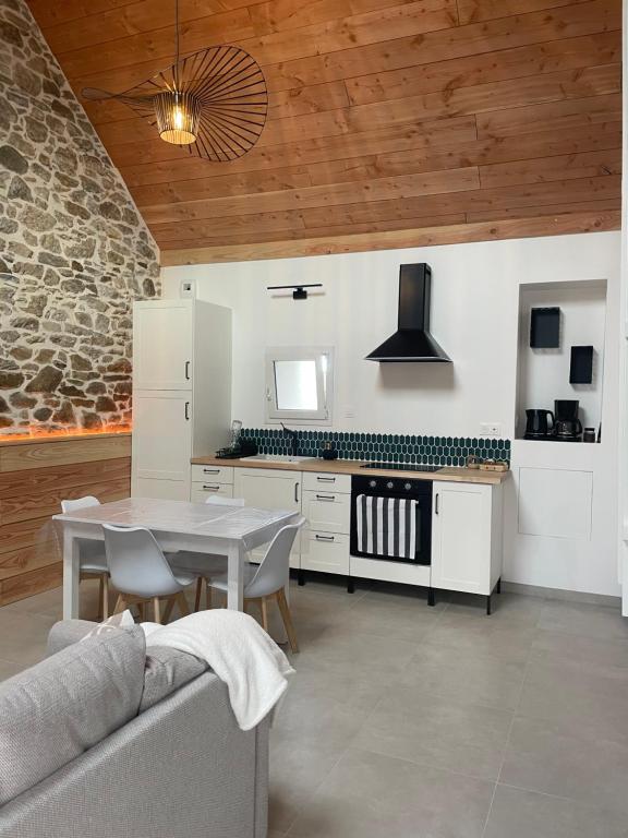 a living room with a table and a kitchen at Maisonnette cosy proche de la côte in Lesneven