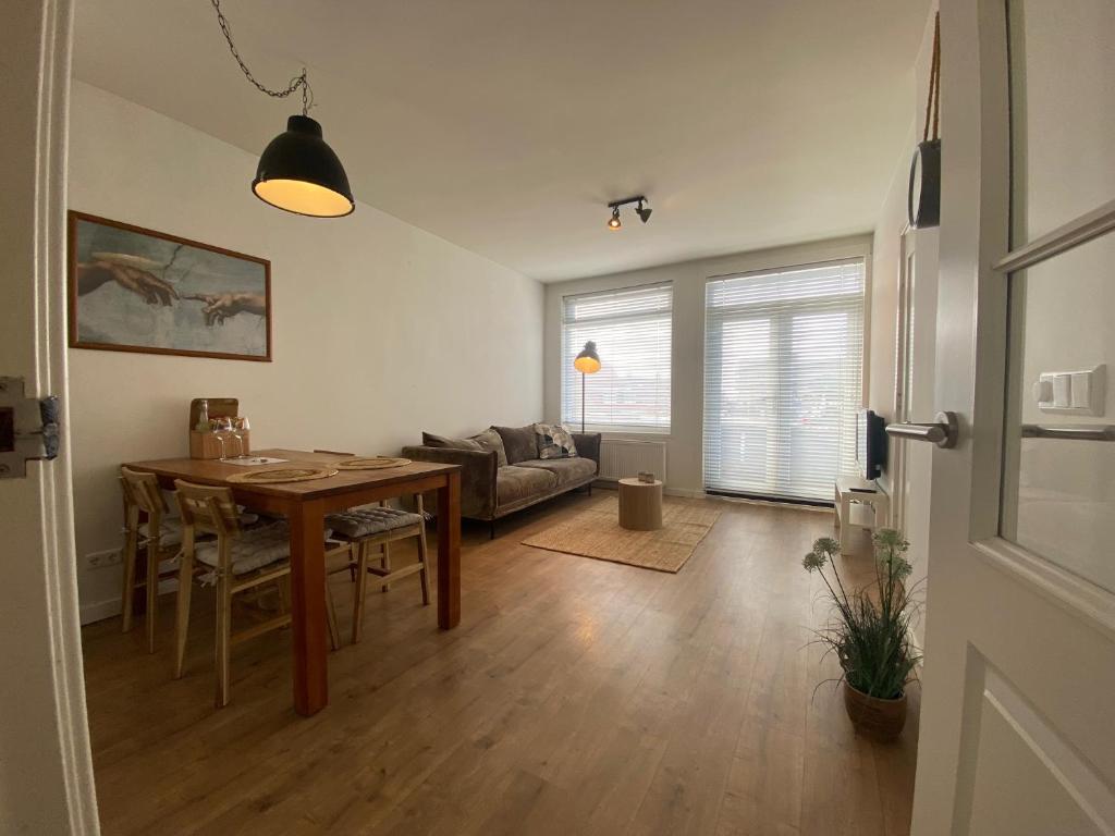 a living room with a table and a couch at NEW Appartment Zandvoort! in Zandvoort