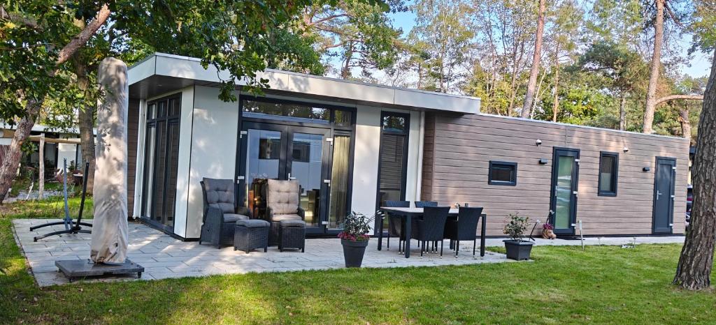 een klein huisje met een tafel en stoelen in een tuin bij casa bosrust in Haarle