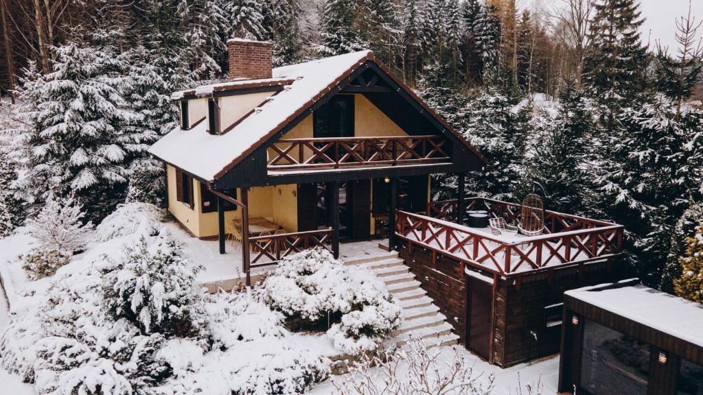une maison recouverte de neige dans les bois dans l'établissement Sowie Klimaty, à Ludwikowice Kłodzkie