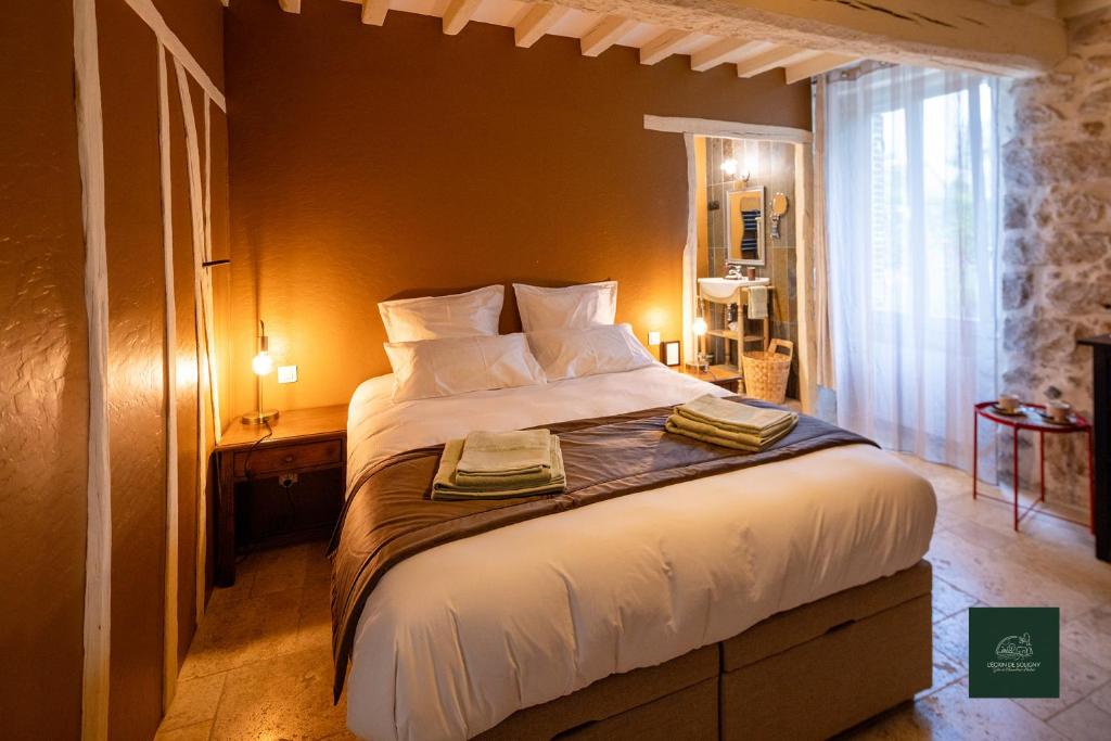 a bedroom with a large bed with white sheets and pillows at Chambre d'hôtes - L'Ecrin de Soligny in Soligny-les-Étangs