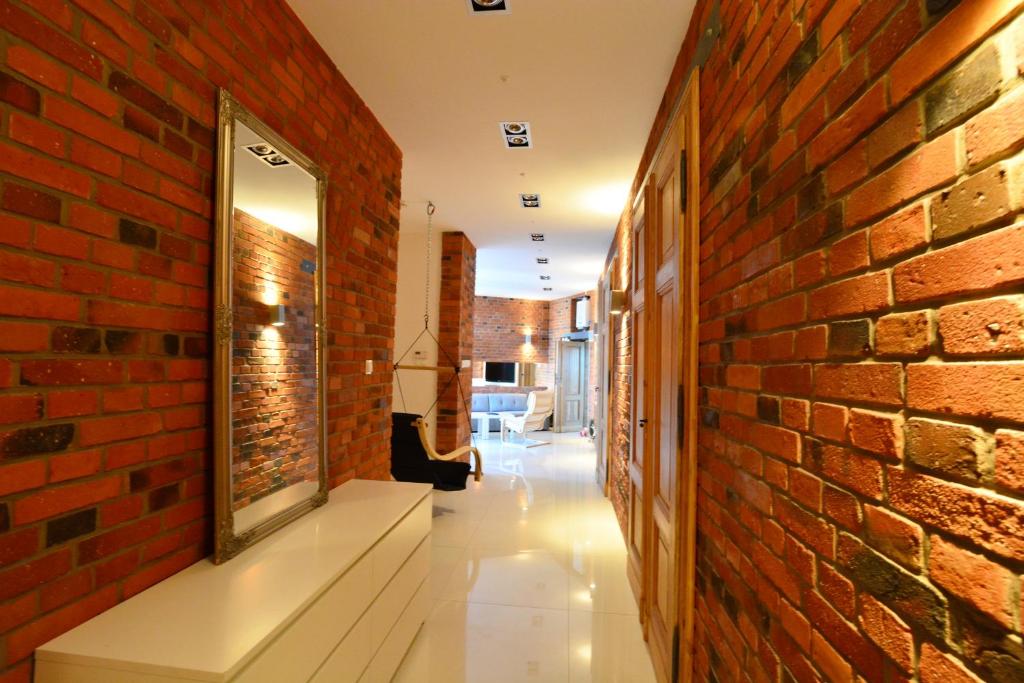 a hallway with a brick wall and a mirror at The Loft in Gliwice