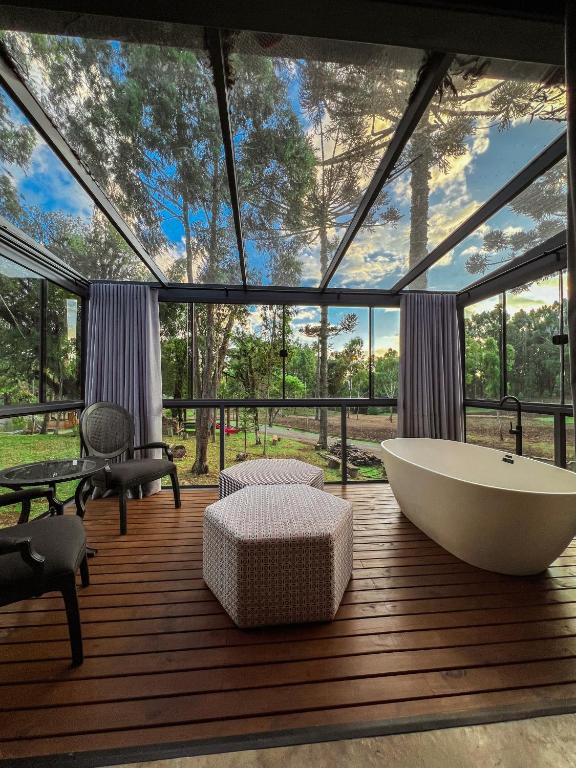 a large bathroom with a tub and a large window at WoodStone Hotel Fazenda in Gramado