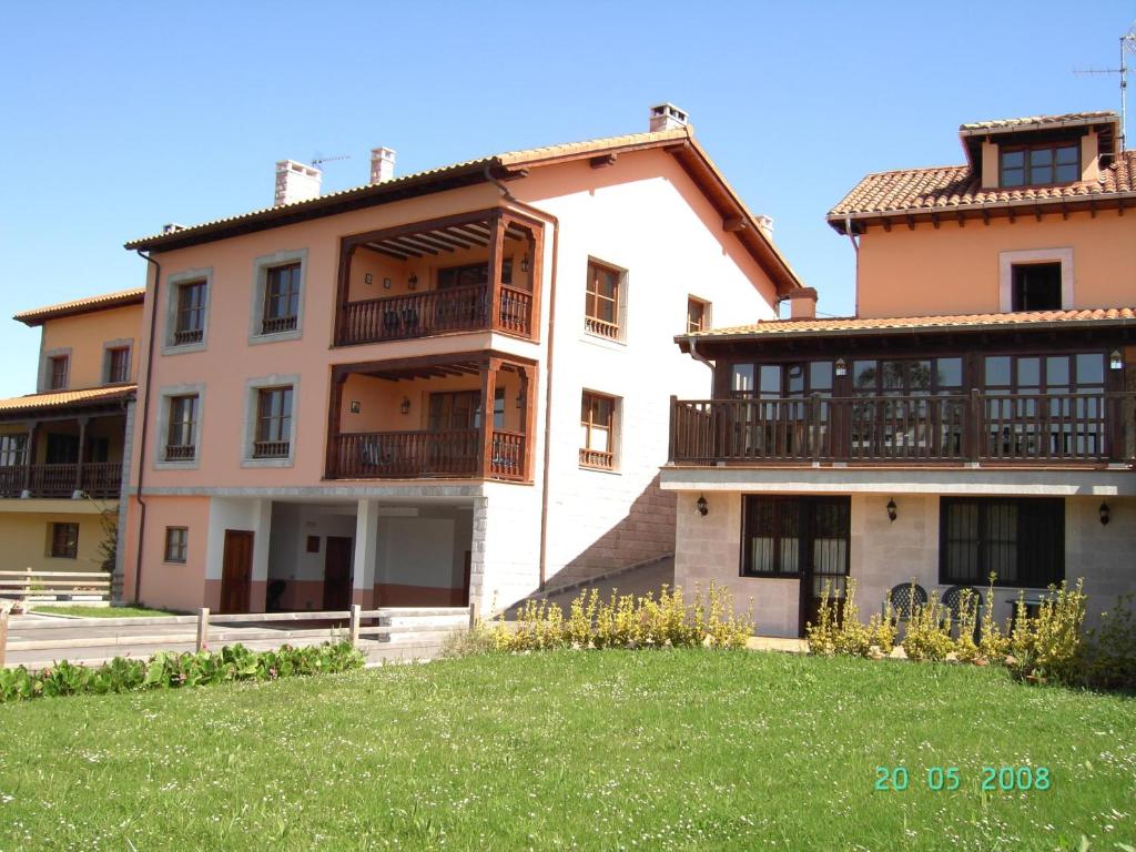 an apartment building with a lawn in front of it at La Arboleda Habitaciones in Colombres