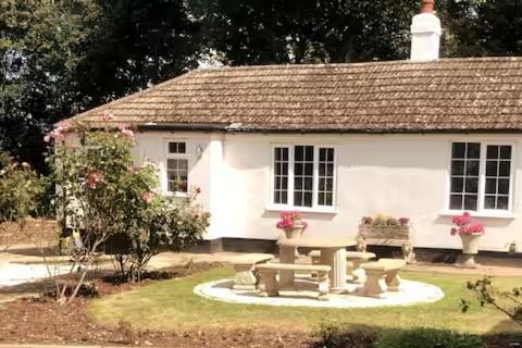 una casa bianca con un tavolo da picnic di fronte di The Priory Cottage a Legbourne