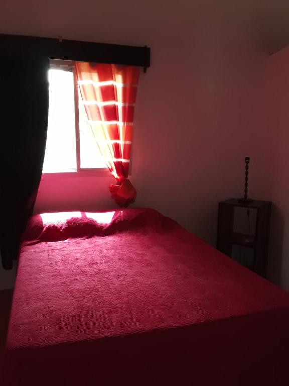 una camera con letto rosa e finestra di Villa 150 mètres Océan a Cap Skirring