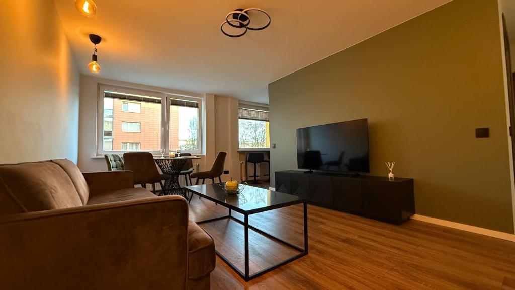 a living room with a couch and a flat screen tv at Baltijos Apartamentai, Self check-in, free parking in Klaipėda