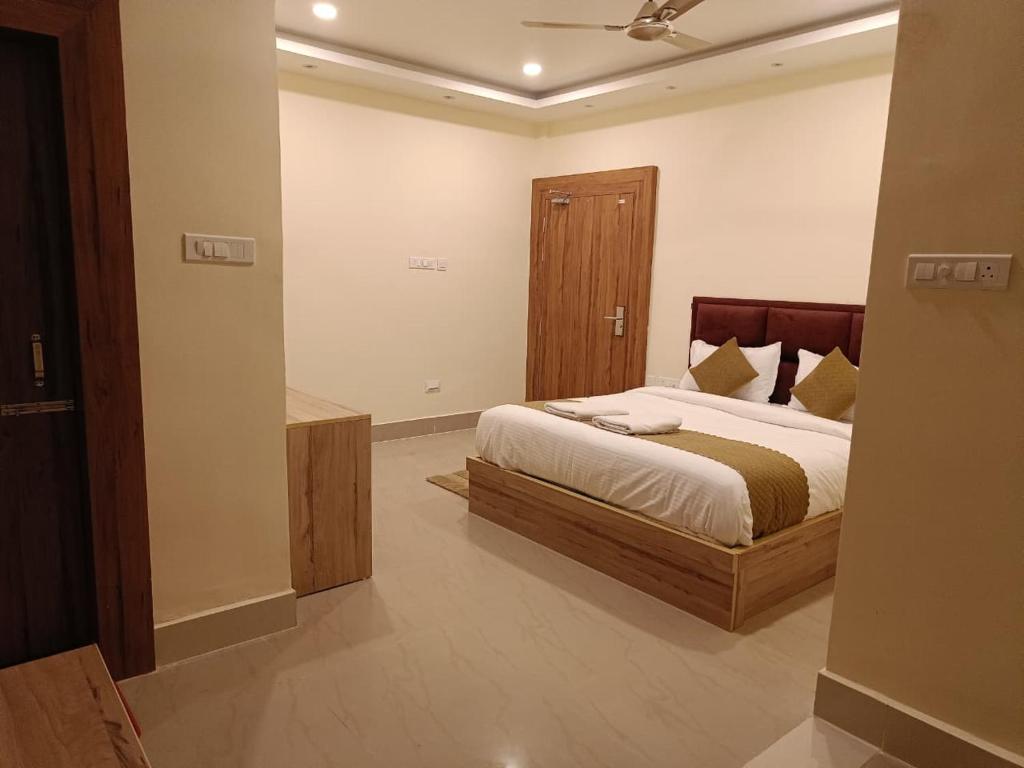 um quarto com uma cama grande com cabeceira de madeira em Hotel SJ corporate em Bhubaneshwar