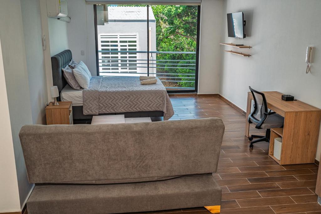 a living room with a couch and a bed at Modern studio apartment with AC and secure parking in Acacías