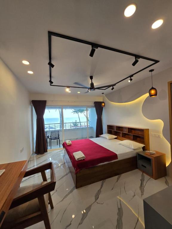 a bedroom with a large bed with a red blanket at Karthik Villa in Varkala