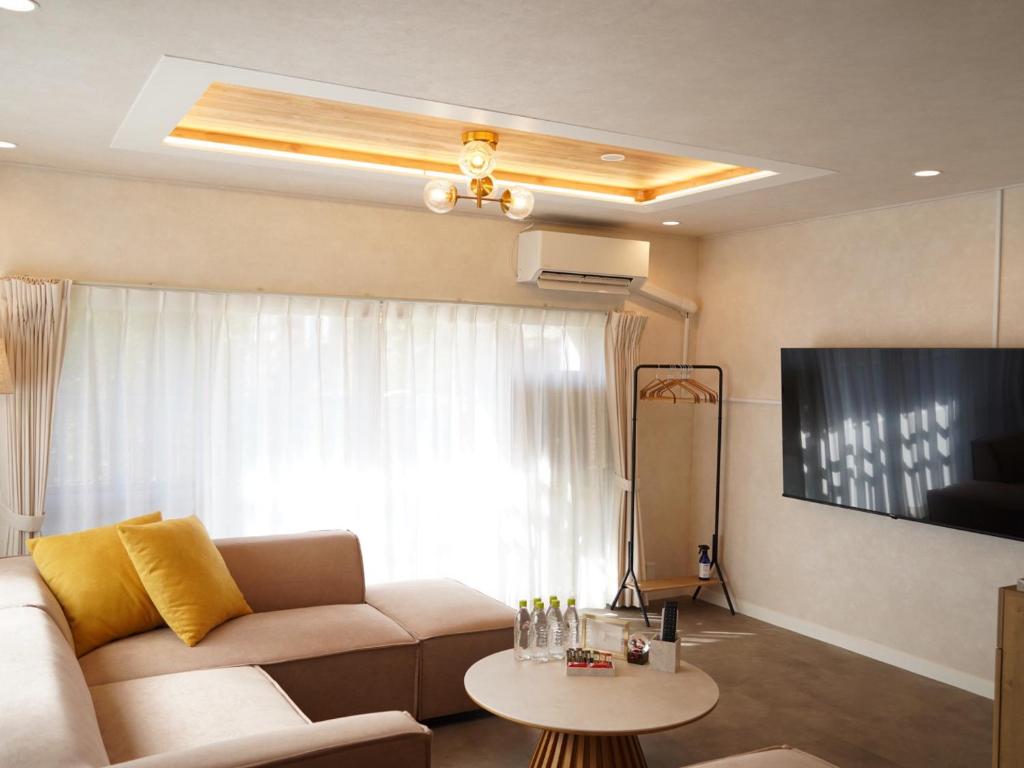 een woonkamer met een bank en een tafel bij スタイリッシュハウス博多 in Fukuoka