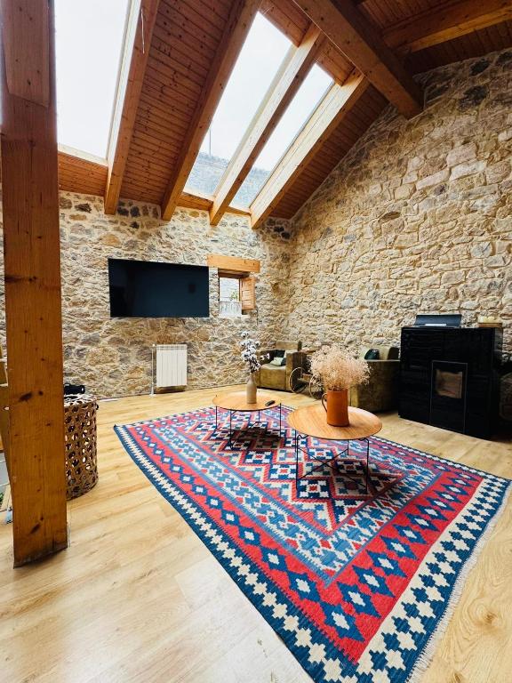 a living room with two tables on a rug at La Casuca De la Iglesia in Ubiarco