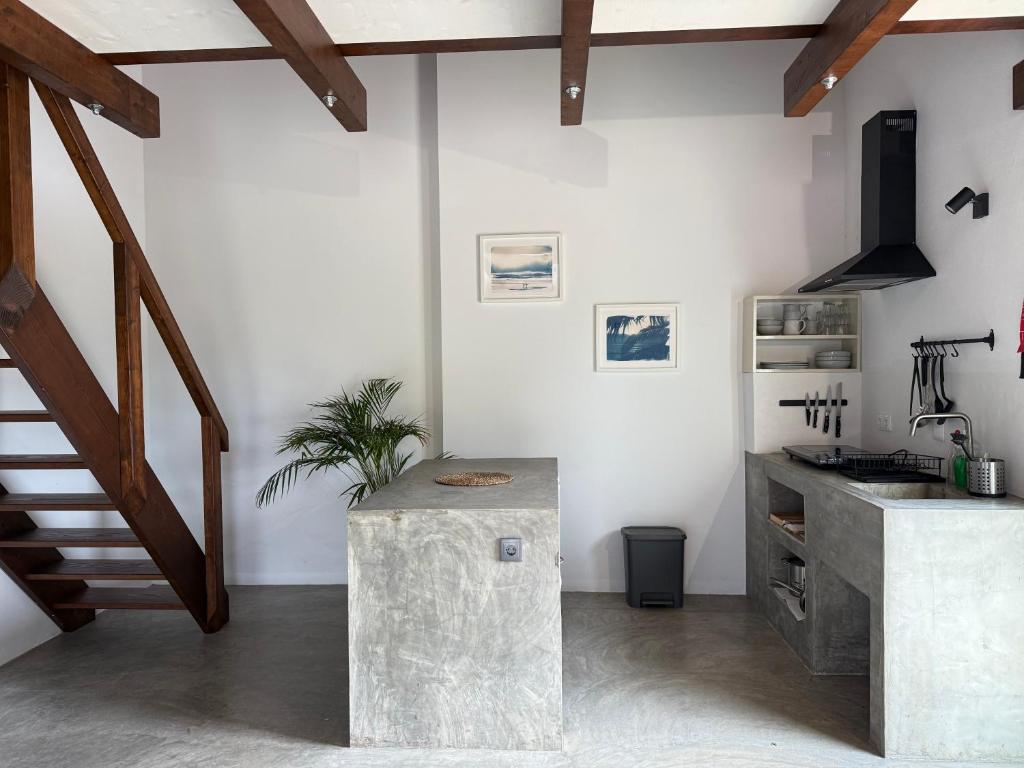 een kamer met een trap, een toonbank en een tafel bij Global Chill Farm Loft in Rogil