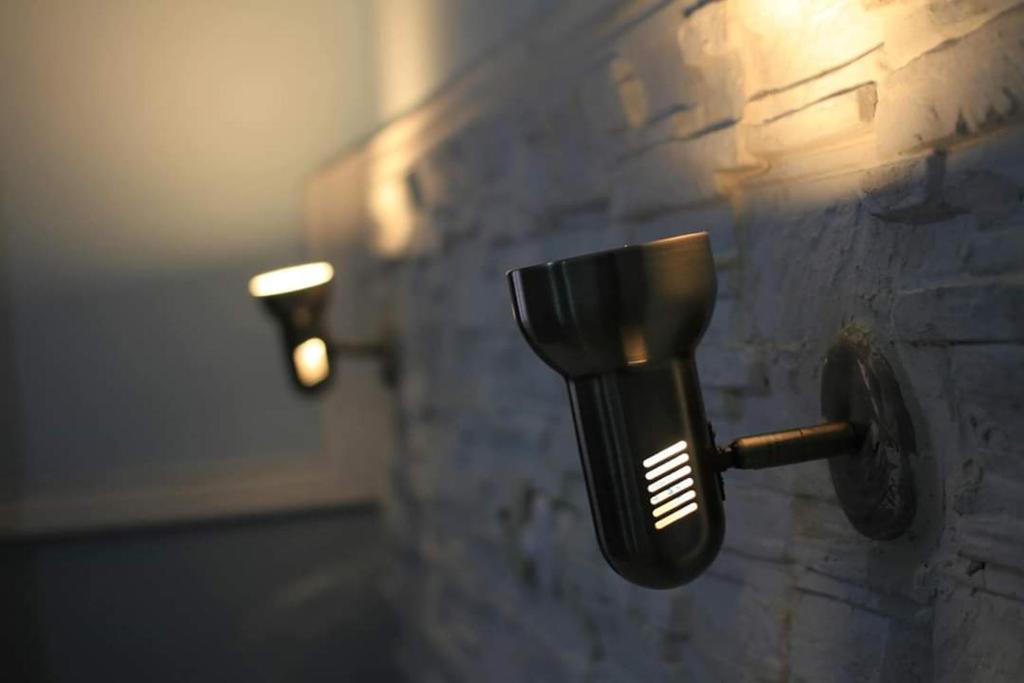 a black soap dispenser on a stone wall at INDRA Hotel in Yaoundé