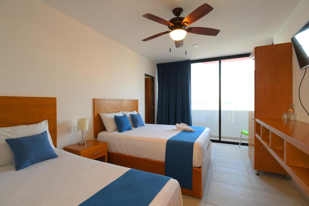um quarto de hotel com 2 camas e uma ventoinha de tecto em Yuum Ha Boutique Hotel em Río Lagartos