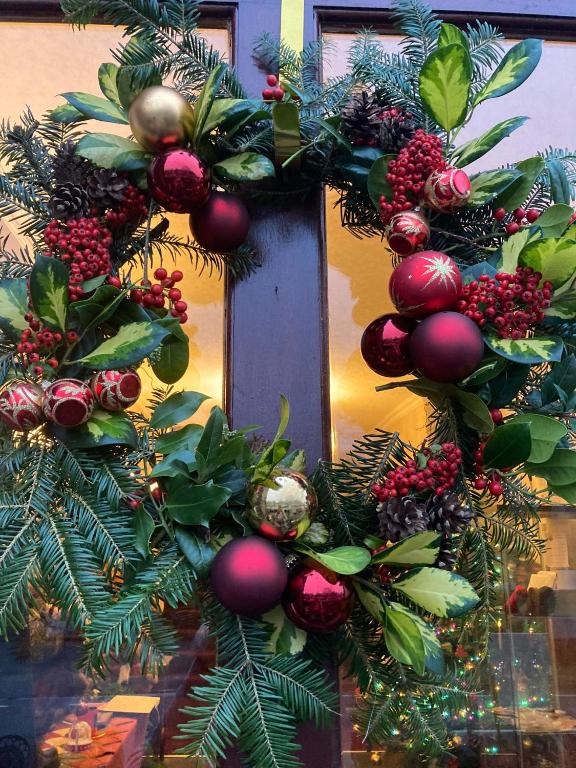 a christmas wreath on a door with christmas decorations at Elen's Castle Bed, Breakfast and Bar in Dolwyddelan