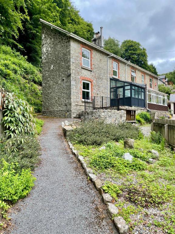 a stone house with a walkway in front of it at Dartmoor Cottage in Bovey Tracey