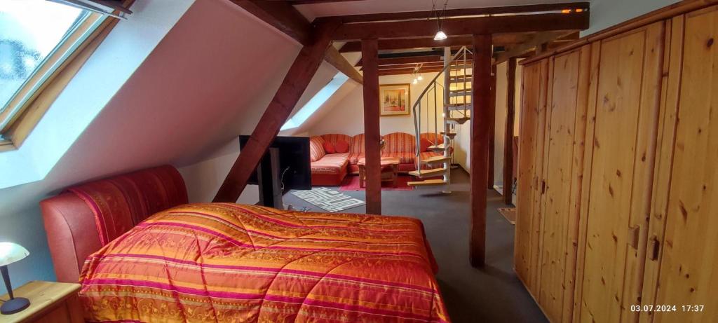 una camera mansardata con un letto in una stanza di DIE HOTELALTERNATIVE DELUXE APP erste Etage mit 2 Schlafzimmer Haus 63 a Solingen