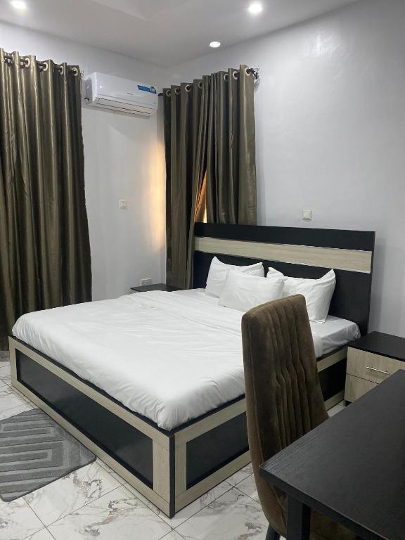 a bedroom with a bed and a desk and a table at Adonai Guesthouse in Agbara