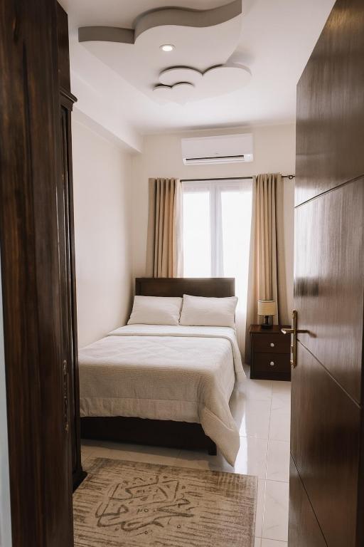 a bedroom with a bed and a window at Al FAHAD private apartments for rent in Luxor