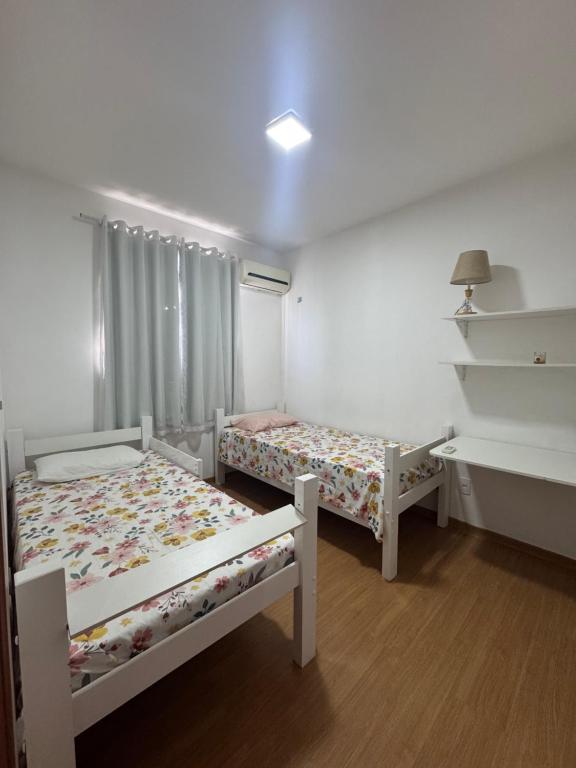 Ένα ή περισσότερα κρεβάτια σε δωμάτιο στο Apartamento Praia de Ponta com dois quartos