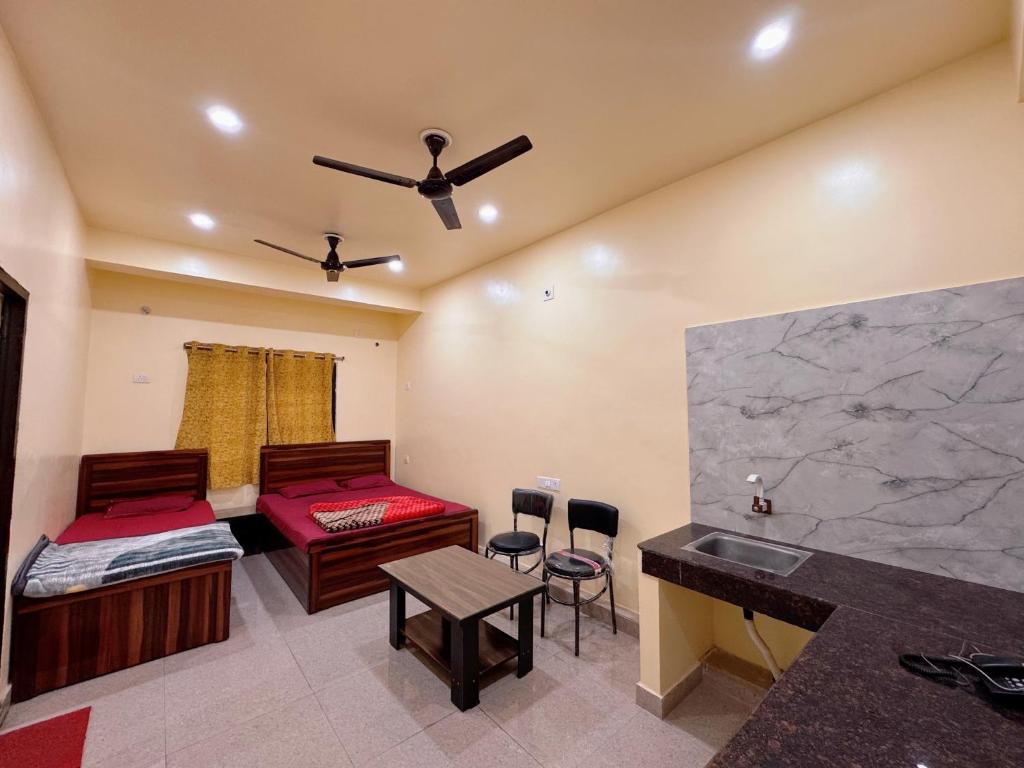 een kamer met 2 bedden, een bureau en een tafel bij Studio 302 Premium Skyline with Terrace view in Deoghar